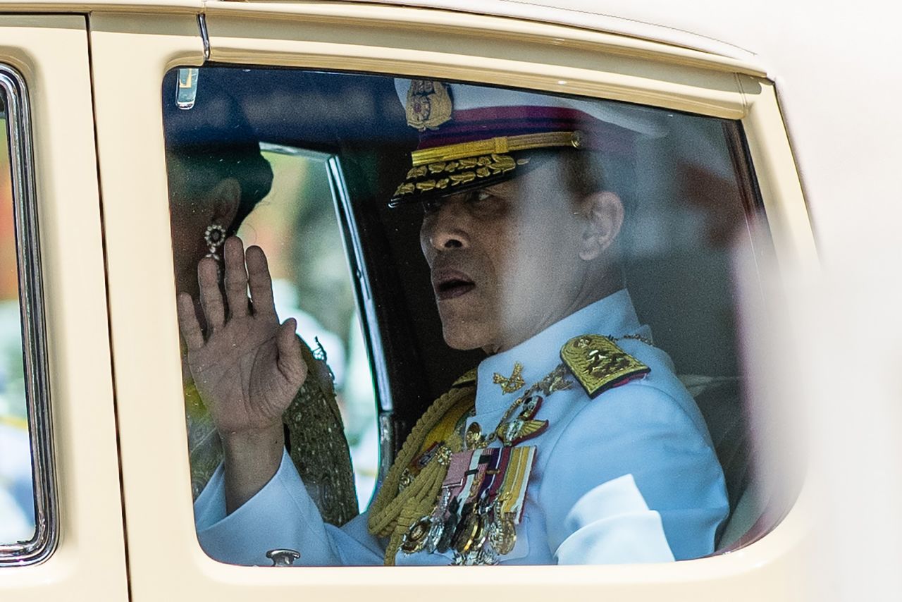 King Maha Vajiralongkorn waves to onlookers as he arrives at the Grand Palace for his coronation.