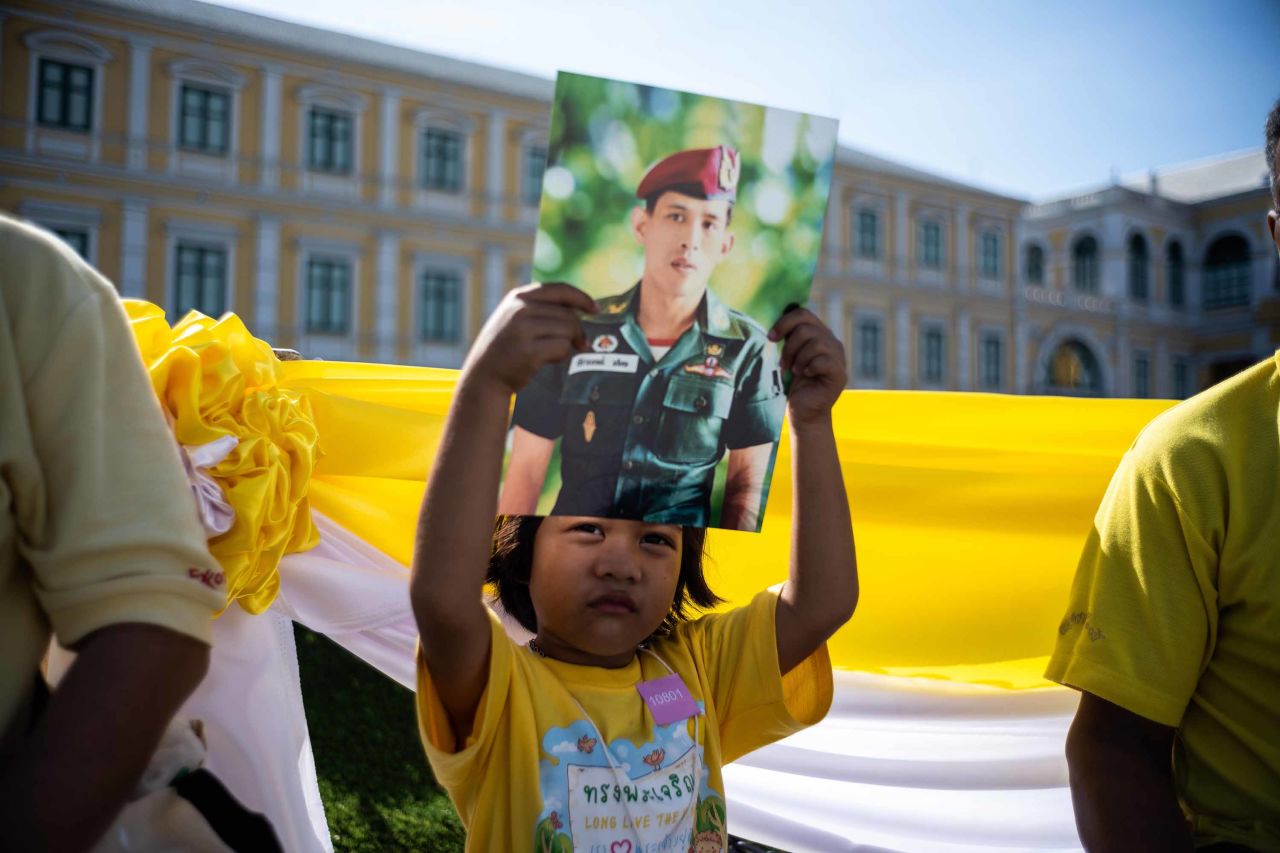 A child holds a portrait of King Vajiralongkorn as she waits with others near the Grand Palace during the coronation on May 4.