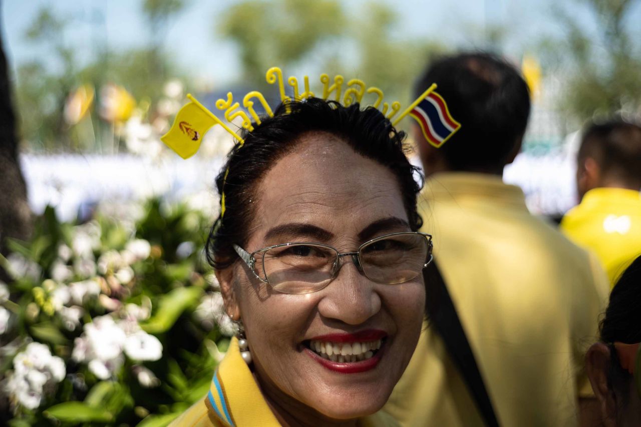 A woman waits near the Grand Palace before the coronation.