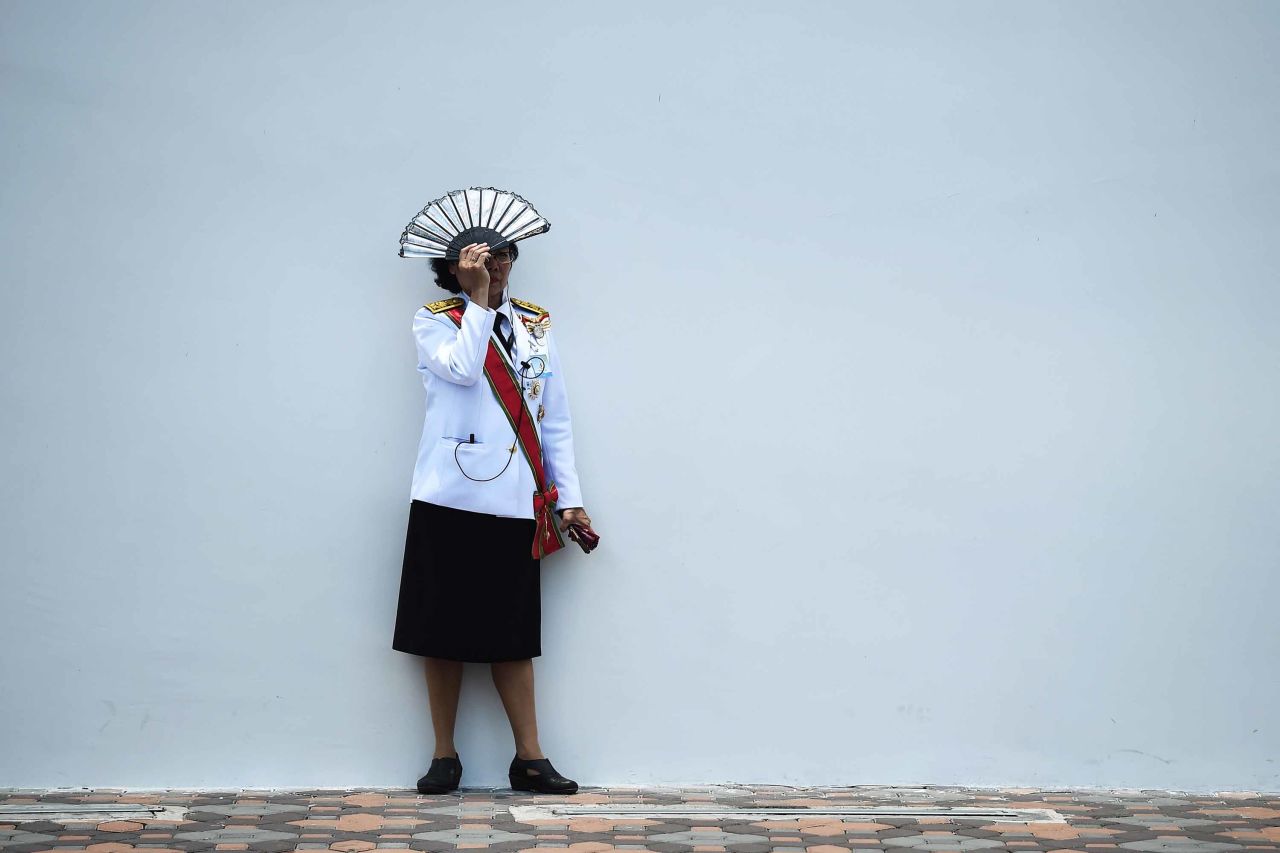 An official shields herself from the sun during the coronation.