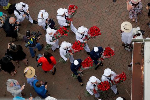 US Navy sailors arrive at Churchill Downs carrying roses before the Kentucky Derby.