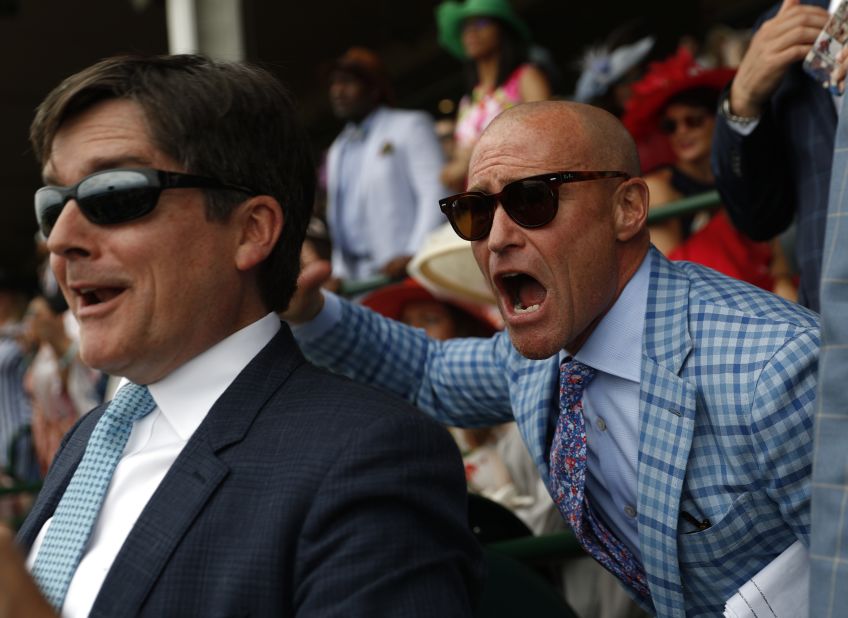 People cheer as they watch a race at Churchill Downs prior to the 145th running of the Kentucky Derby on Saturday, May 4.