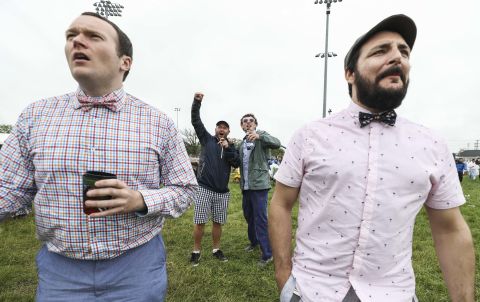 Two race fans cheer for their winning horse while watching a race from the infield prior to the 145th running of the Kentucky Derby.
