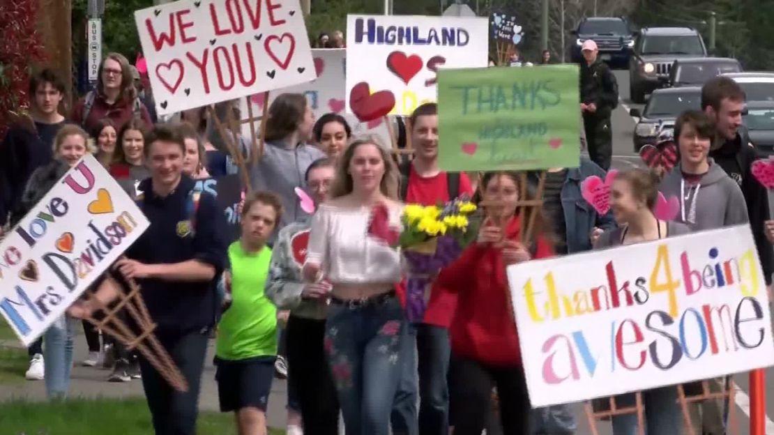 Students carrying signs and flowers walked together to Davidson's home, stood on her lawn and blew her a collective kiss. 