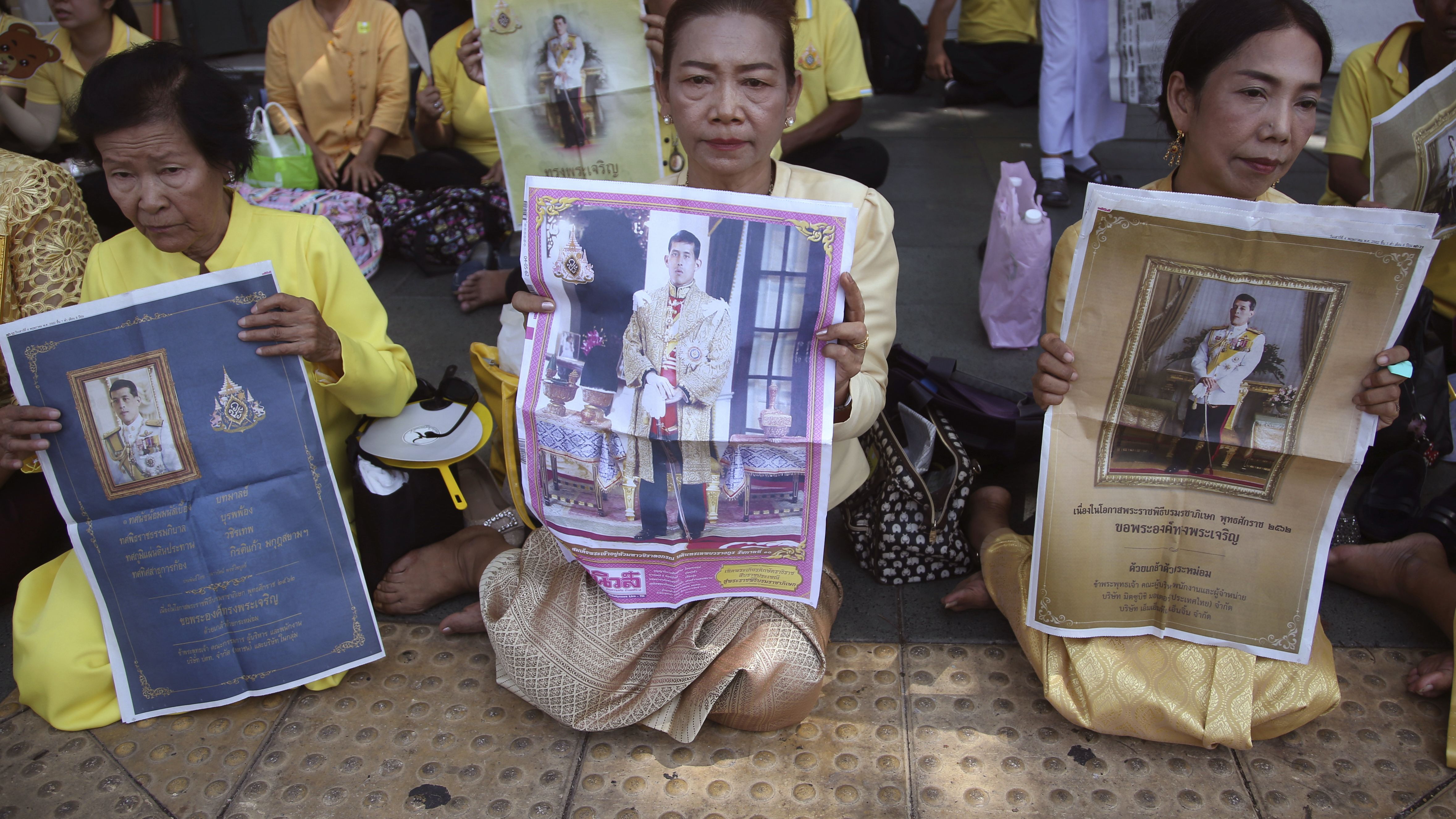 Thai well-wishers hold portraits of Thailand's King Maha Vajiralongkorn outside the Grand Palace on May 5. 