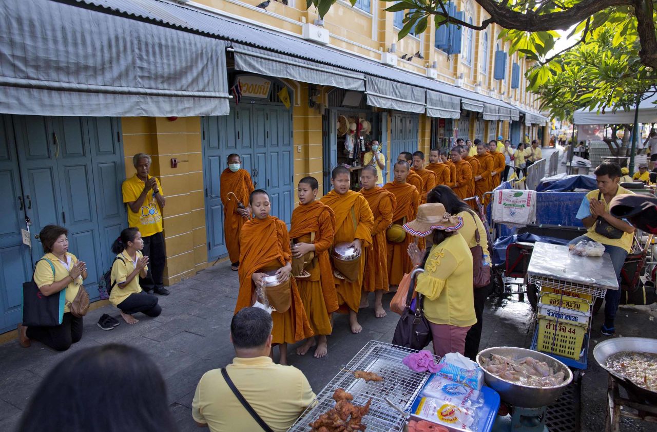 Thai people make offerings to Buddhist monks near the Grand Palace on May 5.