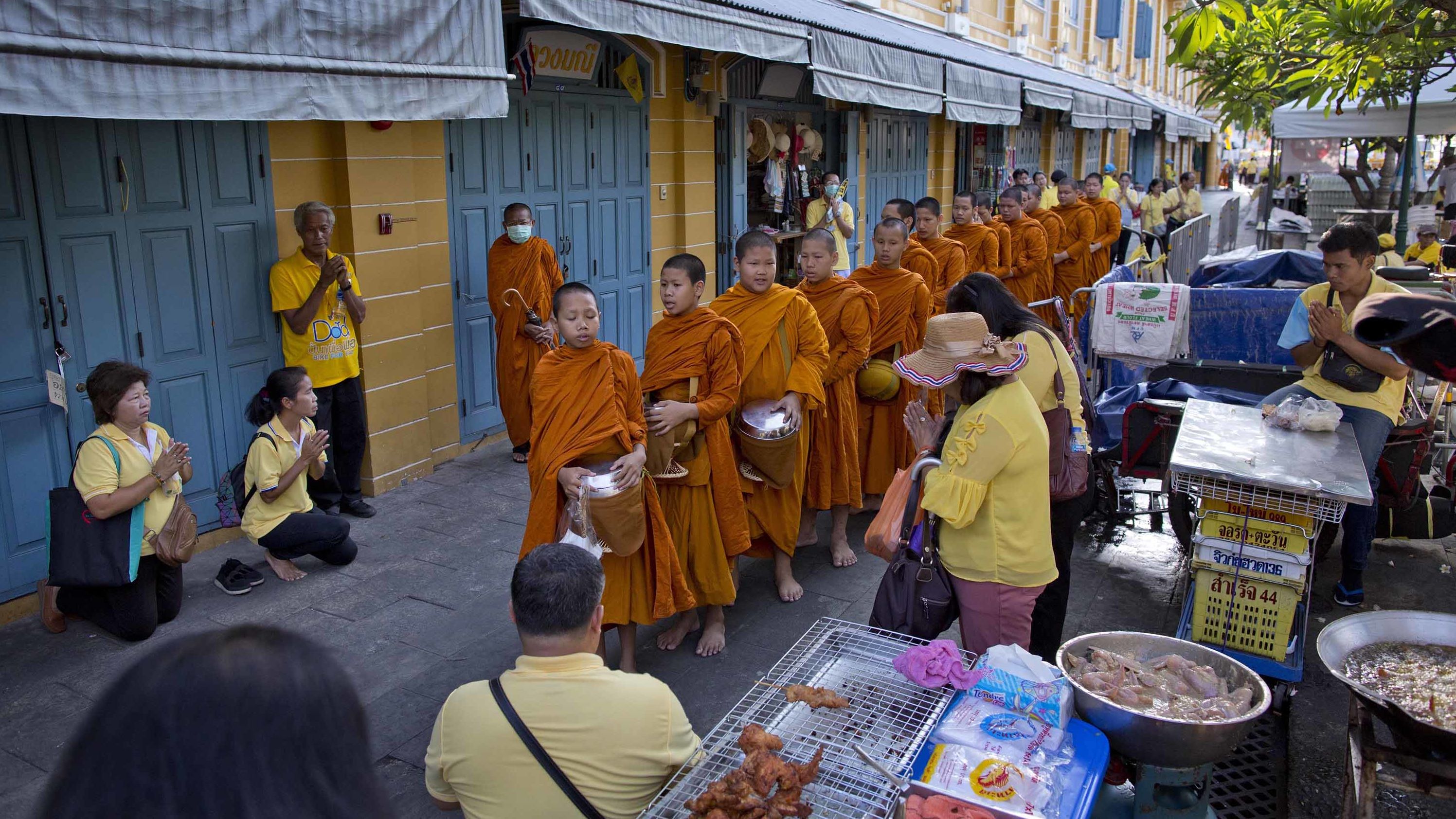 Thai people make offerings to Buddhist monks near the Grand Palace on May 5.