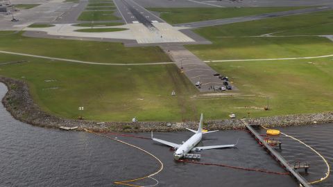 This aerial photo shows the plane in the river after it skidded off the runway in the background.