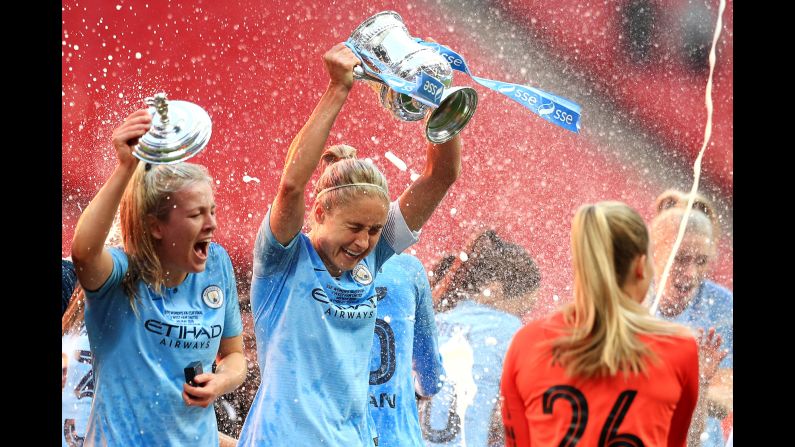 Lauren Hemp, left, and Steph Houghton, center, of the Manchester City Women celebrate with their teammates after winning the Women's FA Cup Final against the West Ham United Ladies at Wembley Stadium on May 4 in London, England.