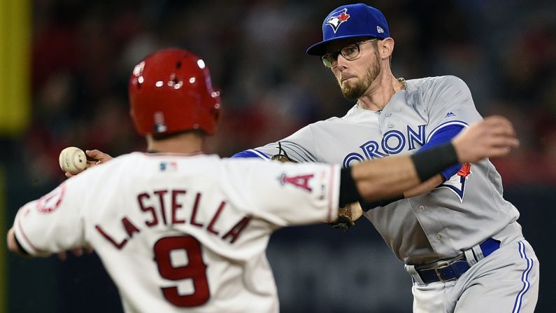 Toronto Blue Jays second baseman Eric Sogard throws to first base over a sliding Tommy La Stella of the Los Angeles Angels during the second inning of an MLB game in Anaheim, California on Tuesday, April 30.