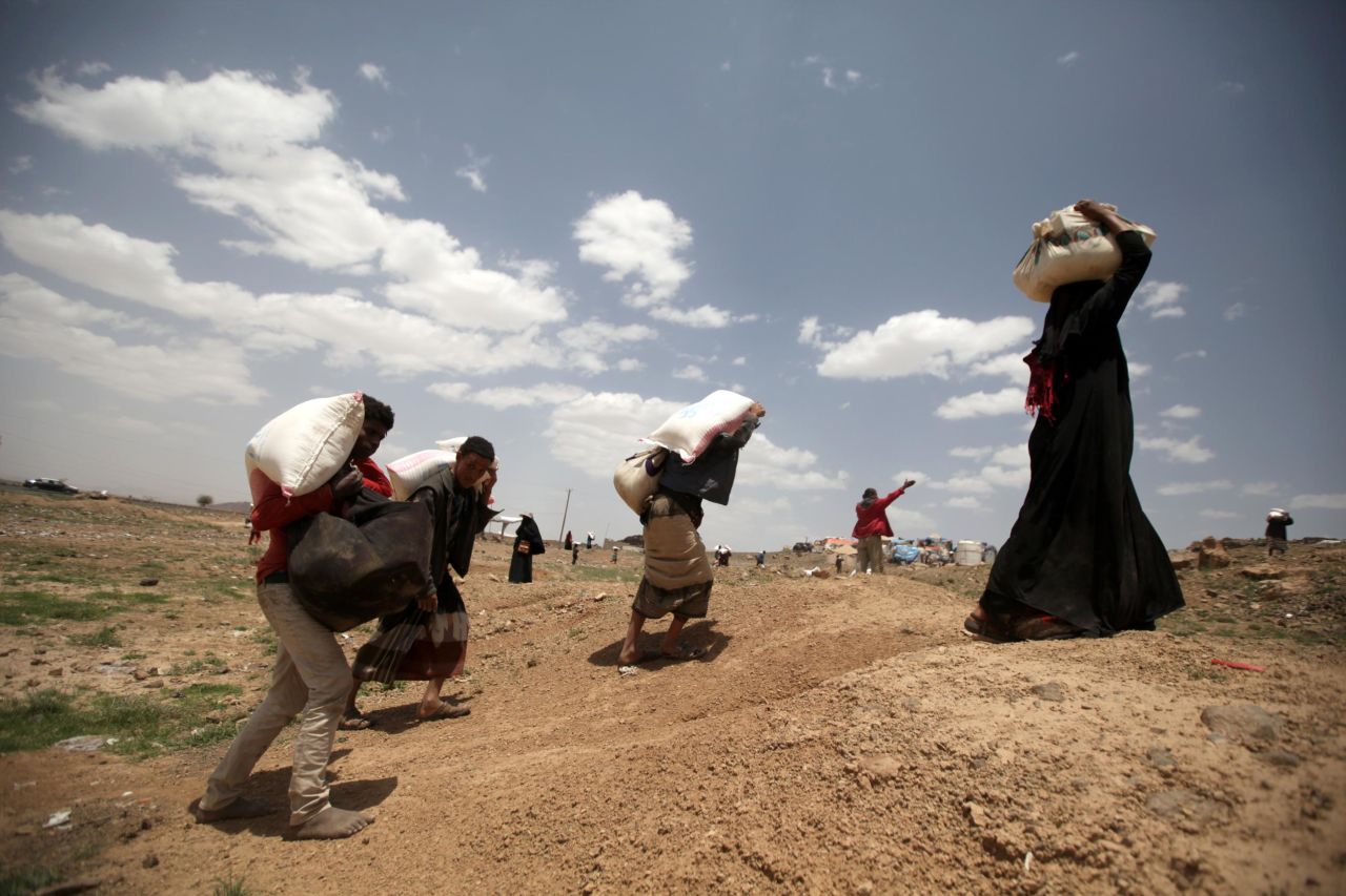 People carry food aid they received from the local charity, Mona Relief, ahead of the holy month of Ramadan on the outskirts of Sanaa, Yemen, on May 5. 