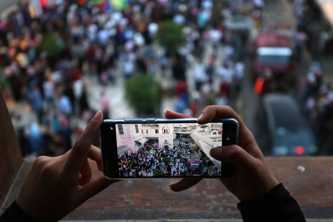 A Muslim takes a picture of a community gathering as people celebrate the first night ahead of the holy fasting month of Ramadan in the West Bank city of Nablus, on May 5.