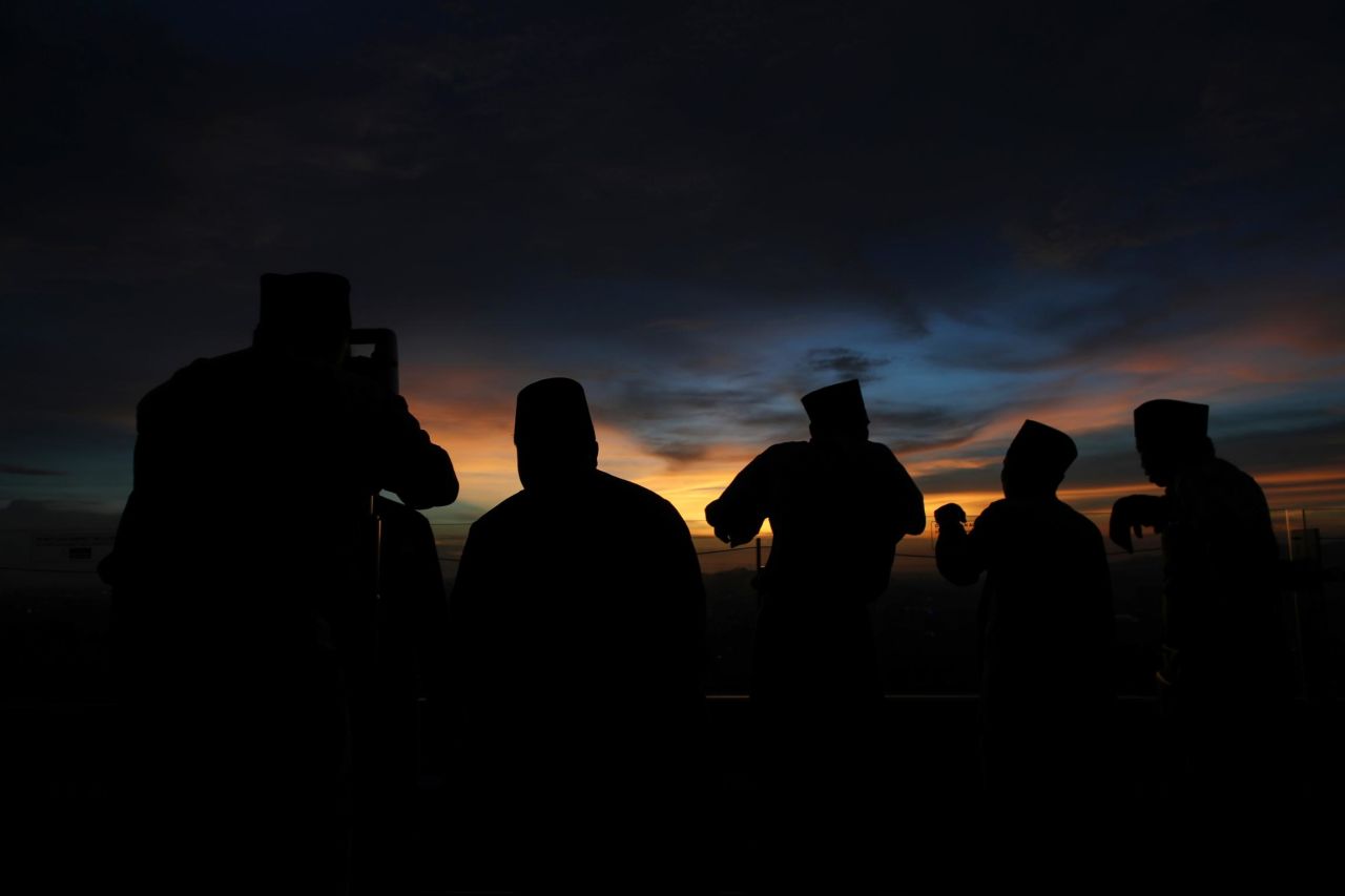 A Malaysian Islamic religious officer, left, observes the position of the moon using a theodolite to determine the sighting of the new moon to mark the start of the holy month of Ramadan in Kuala Lumpur, Malaysia, on May 5.