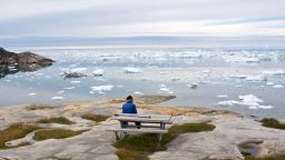 Old man enjoying the view over Ilulissat ice fjord and the Disko bay, West Greenland. 