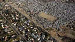 JOHANNESBURG, SOUTH AFRICA - JULY 19: An aerial view of the poor black squatter camp Kya Sands, home to South Africans and many African Immigrants on July 19, 2018 in Johannesburg, South Africa. Across the road Bloubusrand, a middle class area with larger houses and swimming pools. South Africa has one of the highest income differences in the world and the country is struggling with a high unemployment rate and low growth rate. (Photo by Per-Anders Pettersson/Getty Images)