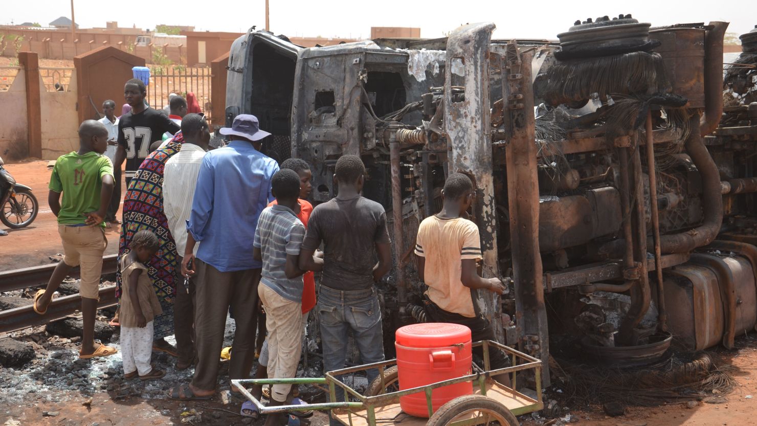 Residents look at a charred tanker truck after an explosion killed more than 55 people near the airport of Niamey. 