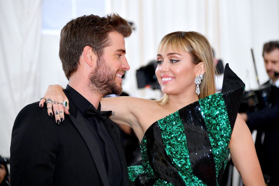 Miley Cyrus arrived in an emerald minidress by Yves Saint Laurent director Anthony Vaccarello, which she paired with Bulgari jewelery. Husband Liam Hemsworth kept things suave and simple in all-black.