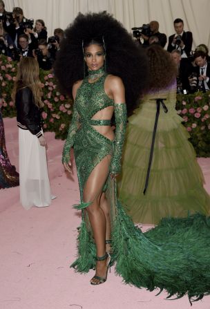 Ciara stunned on the red carpet with a voluminous hairdo and custom emerald gown, complete with ostrich feathered hem, by Dundas. She accessorized with matching belt, gloves and a choker, as well as a House of Malakai headpiece and footwear by Gianvitto Rossi.