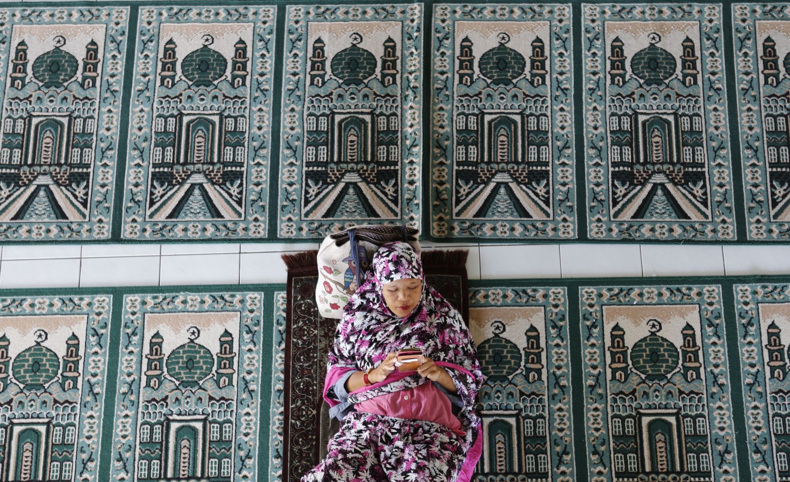 A woman rests at a mosque during the first day of the holy fasting month of Ramadan Monday, May 6, in Bali, Indonesia.