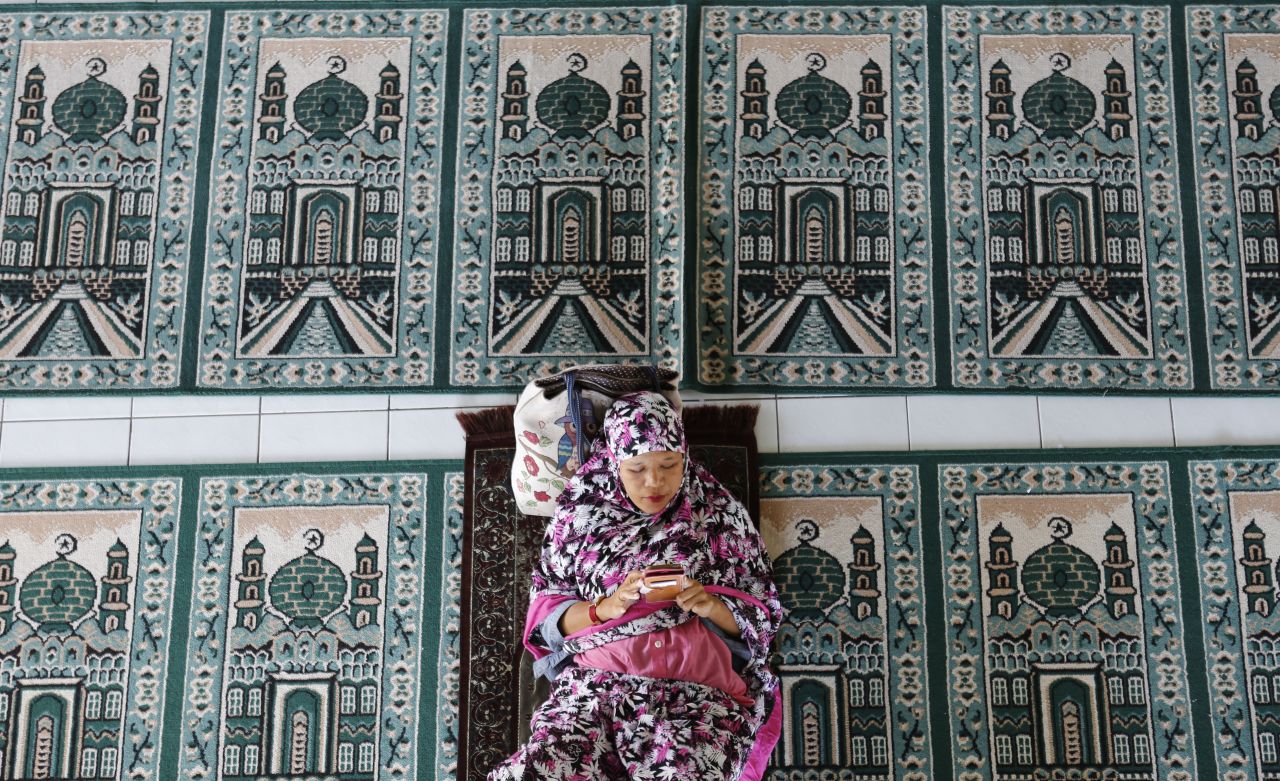 A woman rests at a mosque during the first day of the holy fasting month of Ramadan Monday, May 6, in Bali, Indonesia.