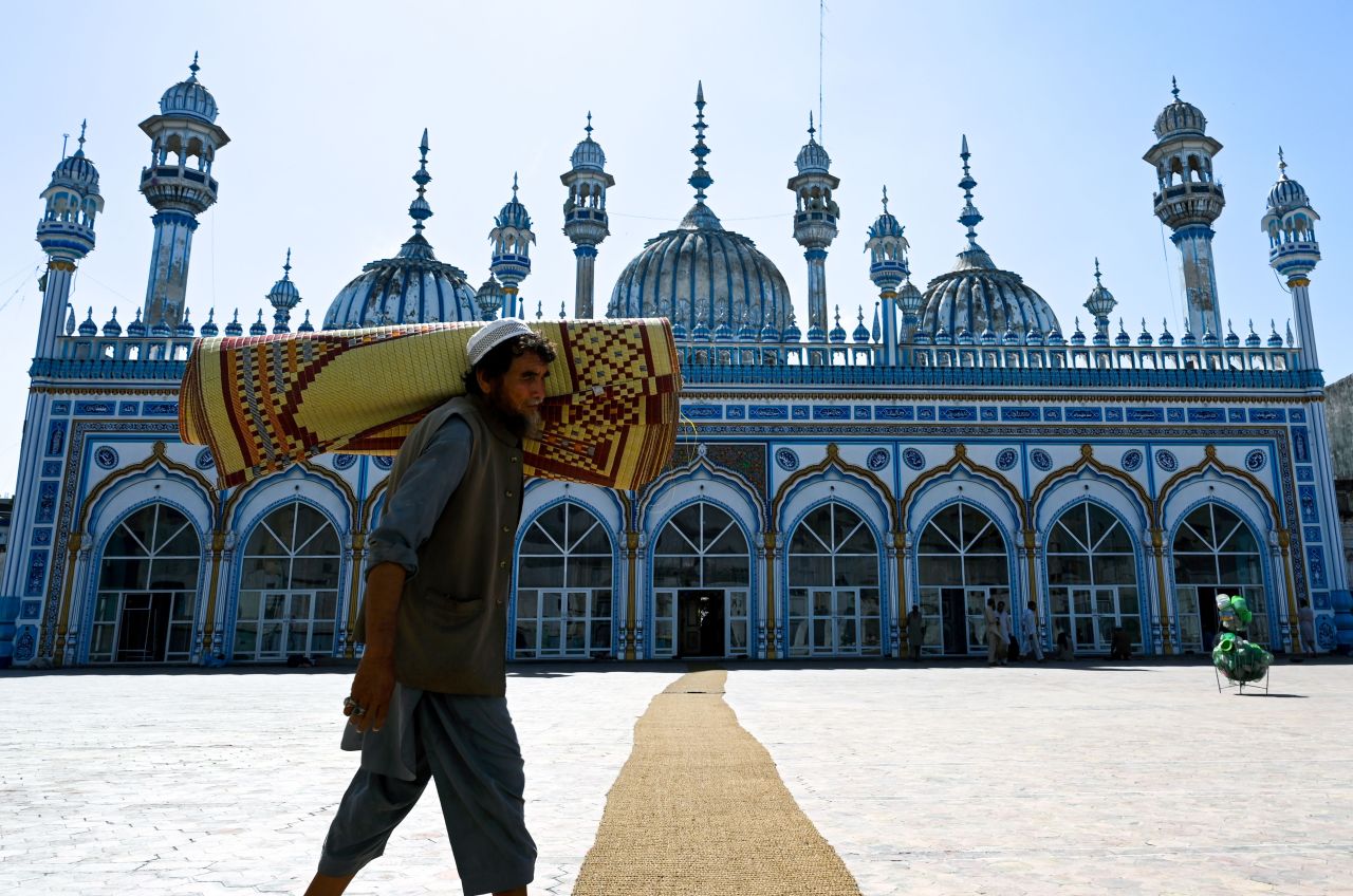 A Pakistani Muslim carries a prayer mat rolled up on his shoulder in preparation for the night special prayers in Rawalpindi on May 6.