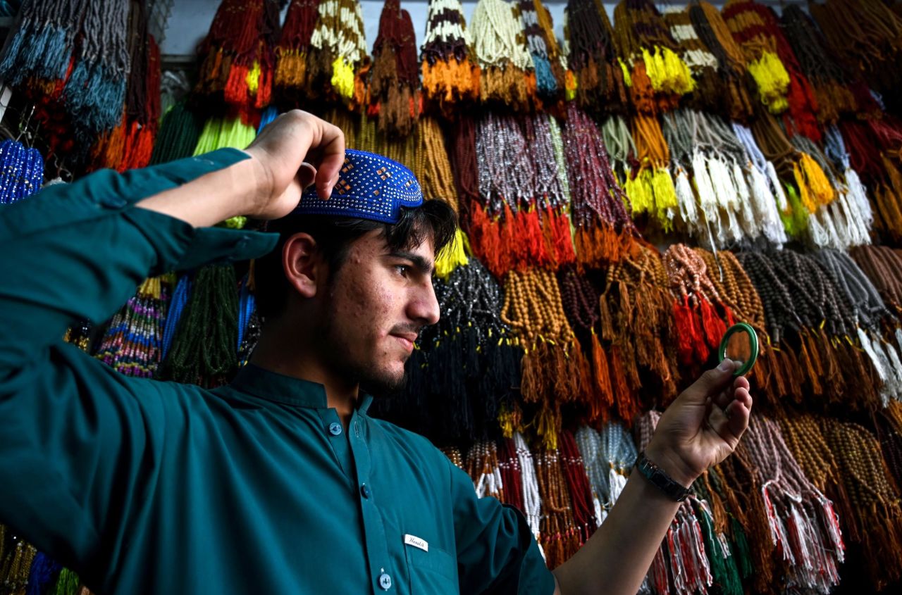 A Pakistani Muslim poses as he tries on a traditional prayer cap at a shop in Rawalpindi on May 6, ahead of the start of the holy fasting month of Ramadan.