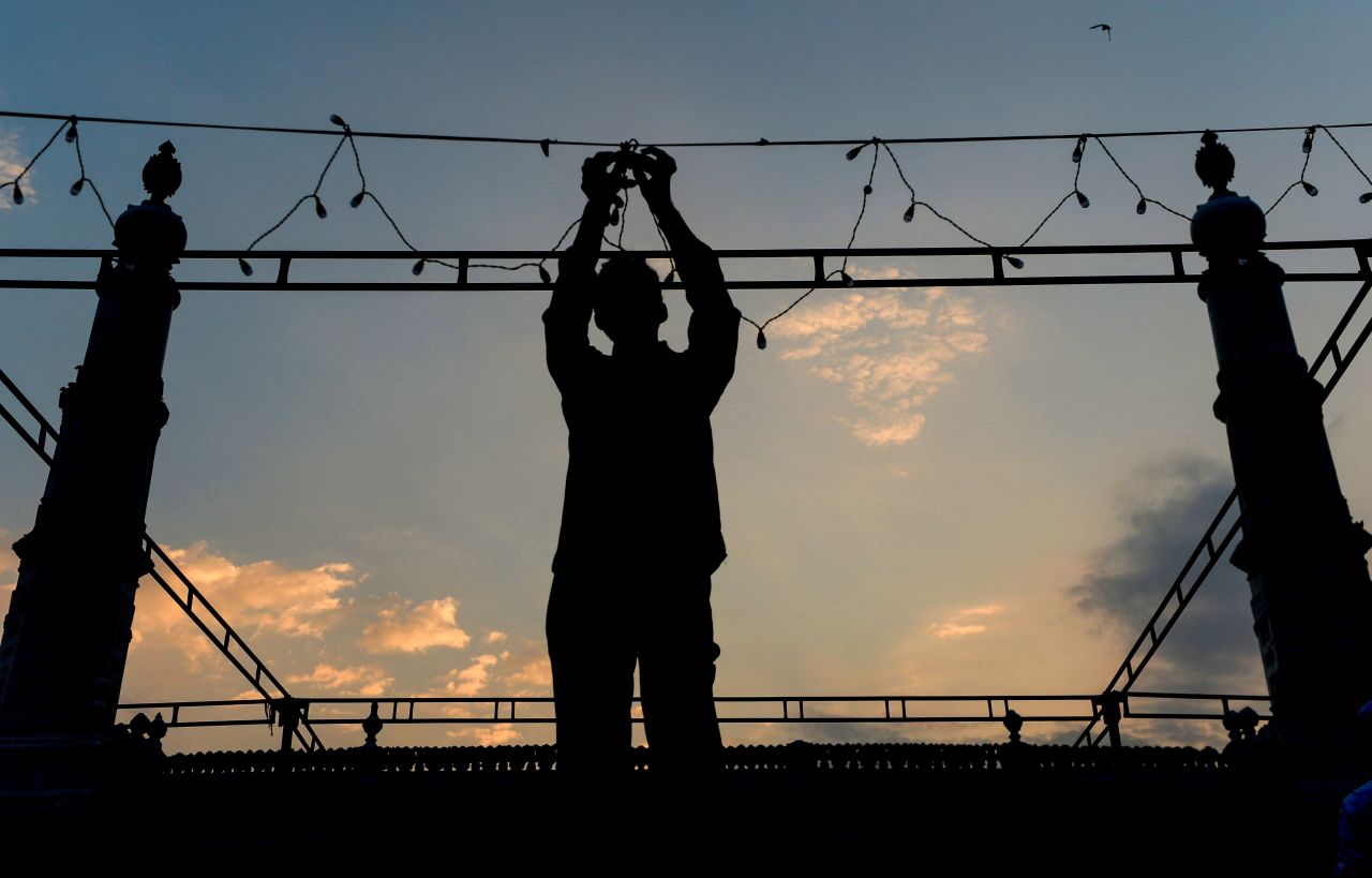 An Indian worker puts on garlands of lights ahead of the start of the holy fasting month of Ramadan at the Wallajah Mosque in Chennai on May 6.
