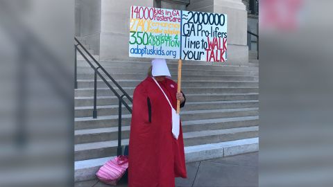 A woman dressed in a red cloak evoking "The Handmaid's Tale" protests outside Georgia's Capitol.