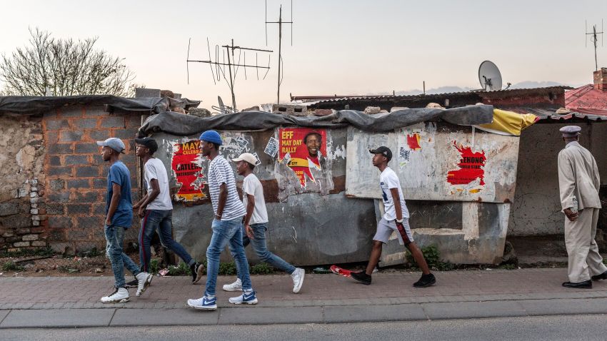 People walk past posters for the South African opposition political party, Economic Freedom Fighters (EFF) in the run up to elections on April 28, 2019 in Johannesburg. - Elections due to take place on May 8, will mark the 25th anniversary of democratic rule in the country. (Photo by GULSHAN KHAN / AFP)        (Photo credit should read GULSHAN KHAN/AFP/Getty Images)