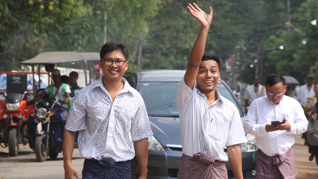 Reuters journalists Kyaw Soe Oo (right) waves beside colleague Wa Lone as they walk out of Insein prison after being freed in a presidential amnesty in Yangon on May 7, 2019. AFP/Getty Images