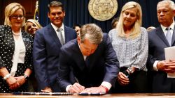 Georgia's Republican Gov. Brian Kemp, center, signs legislation, Tuesday, May 7, 2019, in Atlanta, banning abortions once a fetal heartbeat can be detected, which can be as early as six weeks before many women know they're pregnant. Kemp said he was signing the bill "to ensure that all Georgians have the opportunity to live, grow, learn and prosper in our great state." (Bob Andres/Atlanta Journal-Constitution via AP)