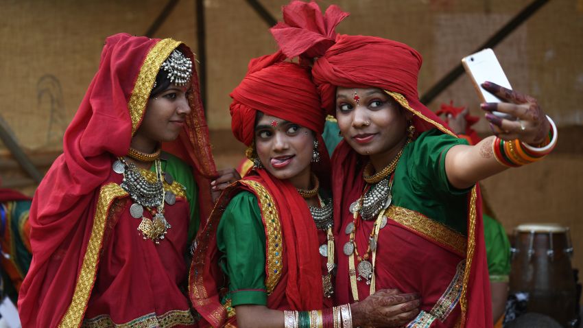 TOPSHOT - Indian artists from central India of Madhya Pradesh take selfie  before performing in a cultural event organised by Indira Gandhi National Centre for Arts in New Delhi on November 29, 2017. / AFP PHOTO / SAJJAD HUSSAIN        (Photo credit should read SAJJAD HUSSAIN/AFP/Getty Images)