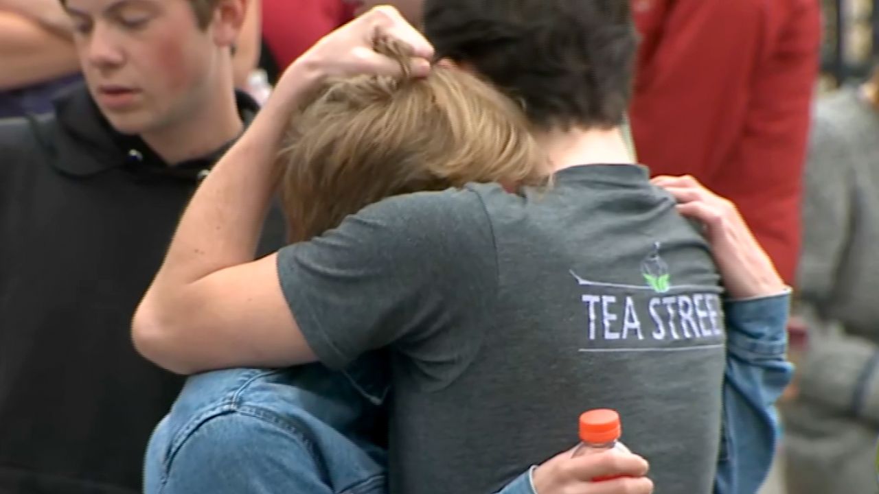 Students at the STEM school hug Tuesday after two suspects opened fire inside the school.