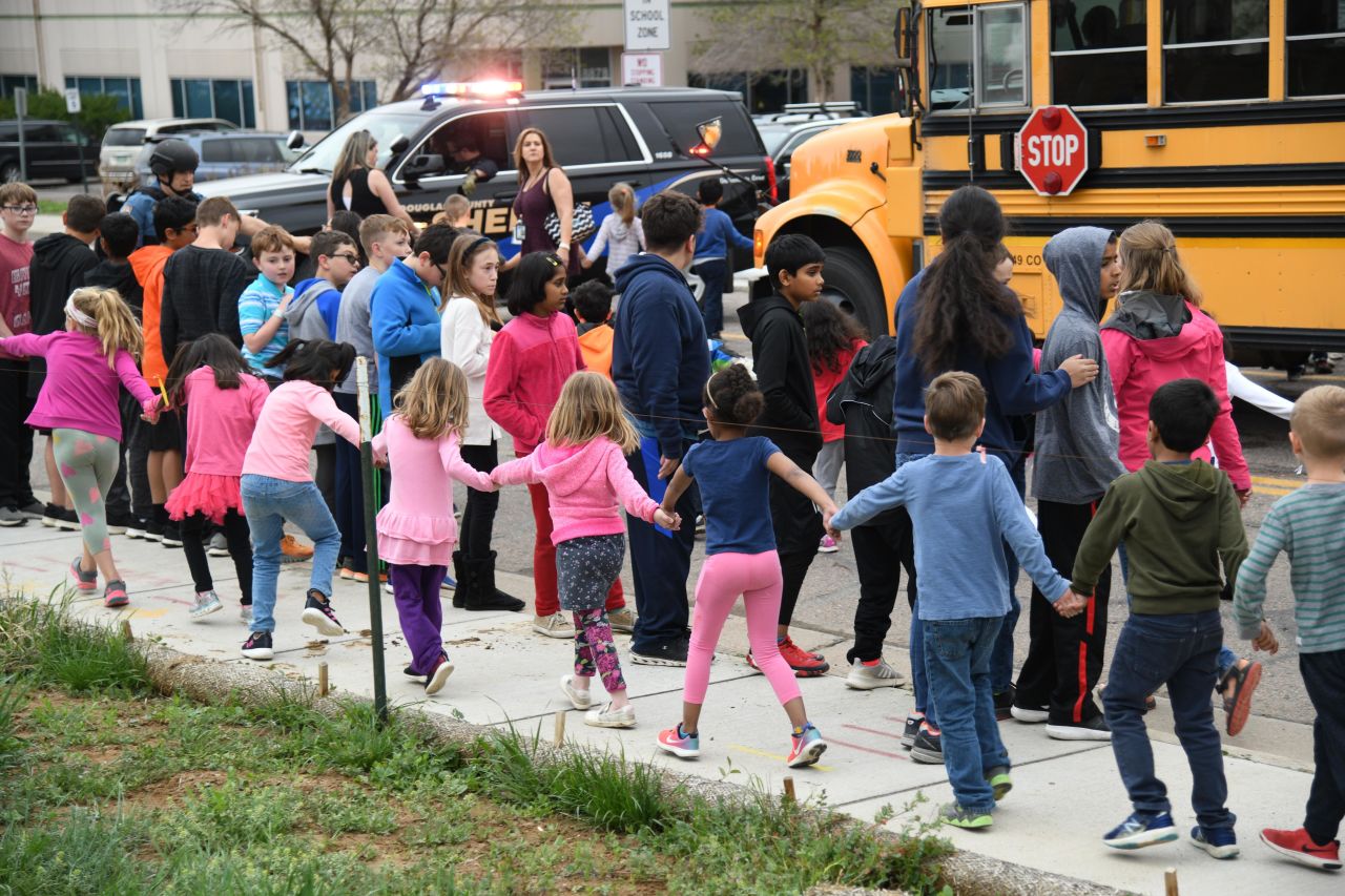 Students are escorted to school buses after the shooting on May 7.