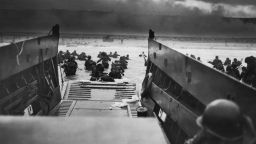 The Allied Forces stromed the beaches of Normandy, france on June 6, 1944.  Here American troops hit the water from one of the landing craft.  Soldiers on shore are lying flat under German machine gun fire. Robert F. Sargent, a Coast Guard photographer, took this view from a landing barge.
