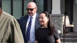 Huawei Chief Financial Officer Meng Wanzhou, right, who is out on bail and remains under partial house arrest after she was detained Dec. 1 at the behest of American authorities, is accompanied by a private security detail as she leaves her home to attend a court appearance in Vancouver, British Columbia, Wednesday, May 8, 2019. (Darryl Dyck/The Canadian Press via AP)