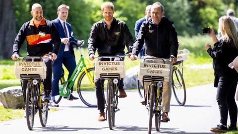 Former Dutch military sodlier and athlete Dennis van der Stroom, Britain's Prince Harry and host Lieutenant General Mart de Kruif ride bides during the presentation of The Invictus Games in The Hague.
