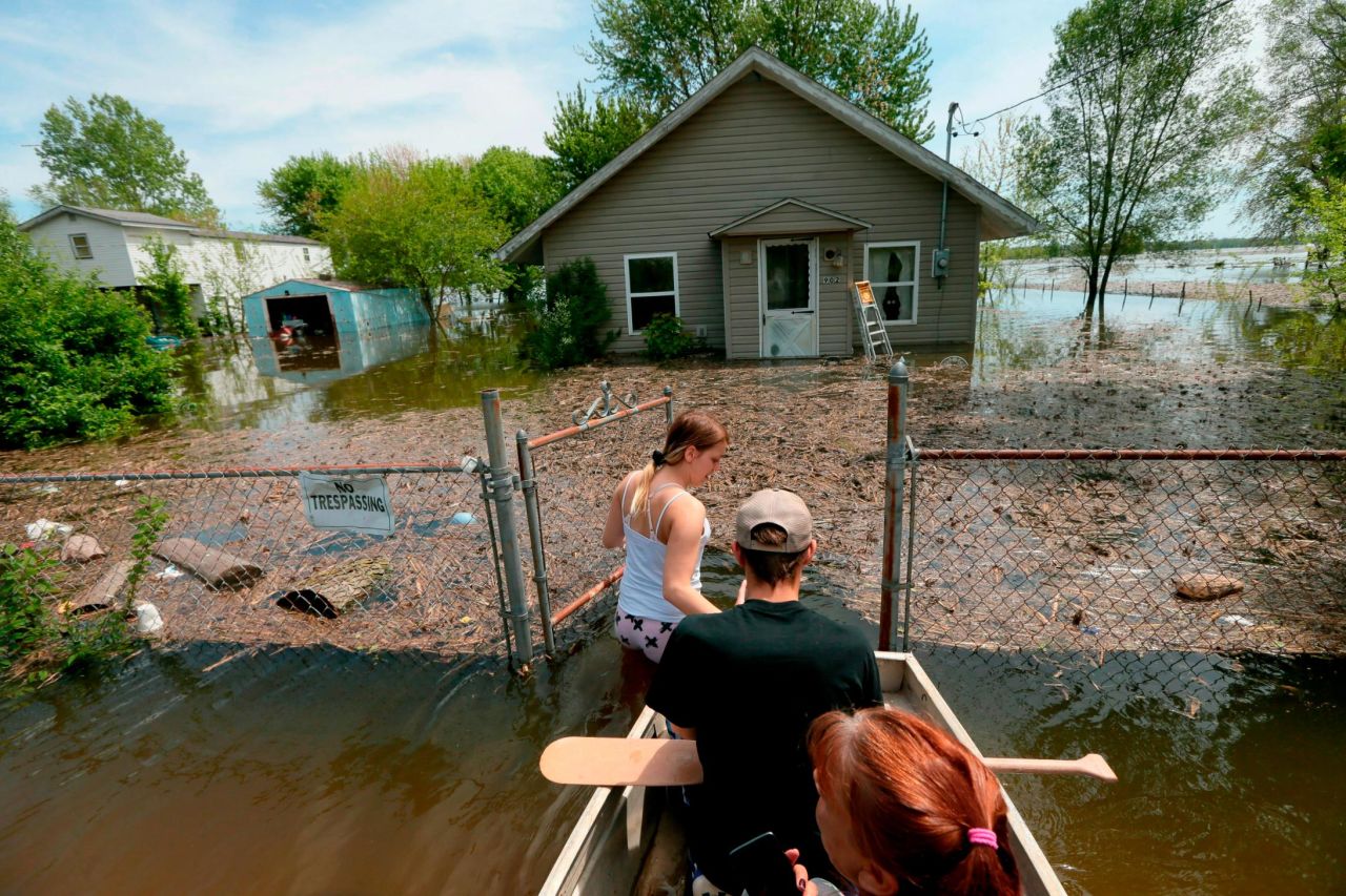 While wading in floodwaters in East Foley, Missouri, Marissa Whitman guides a boat carrying her boyfriend, Brendan Cameron, and his mother, Tory Cameron, on Sunday, May 5. They were returning to their home a day after evacuating the area. The flooding occurred as <a href="https://www.cnn.com/2019/05/03/us/storm-related-deaths-wxc/index.html" target="_blank">a slow-moving storm</a> made its way from southern Texas through the Ohio River Valley.