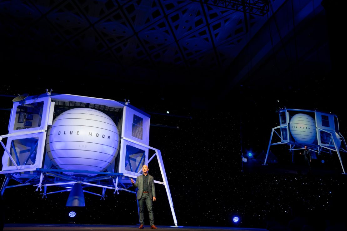 Jeff Bezos stands in front of a Blue Origin prototype of a lunar lander named Blue Moon.