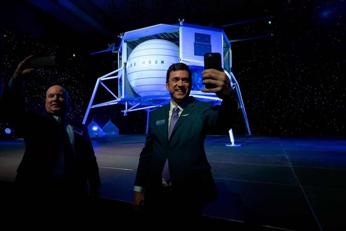 Attendees take selfies in front of the Blue Moon lunar lander after the presentation.