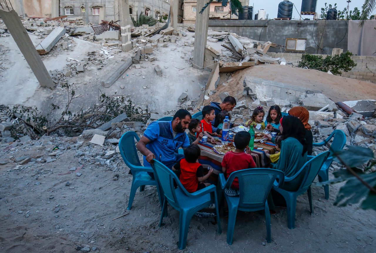 A Palestinian family break their fast next to their house, which was destroyed in recent confrontation between Hamas and Israel, in Rafah, the southern Gaza Strip.