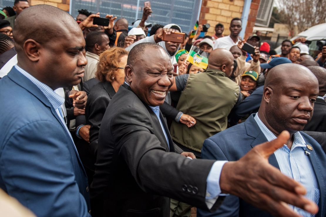 Cyril Ramaphosa greets voters as he arrives to cast his vote.