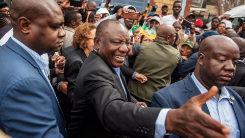 Cyril Ramaphosa greets voters as he arrives to cast his vote.