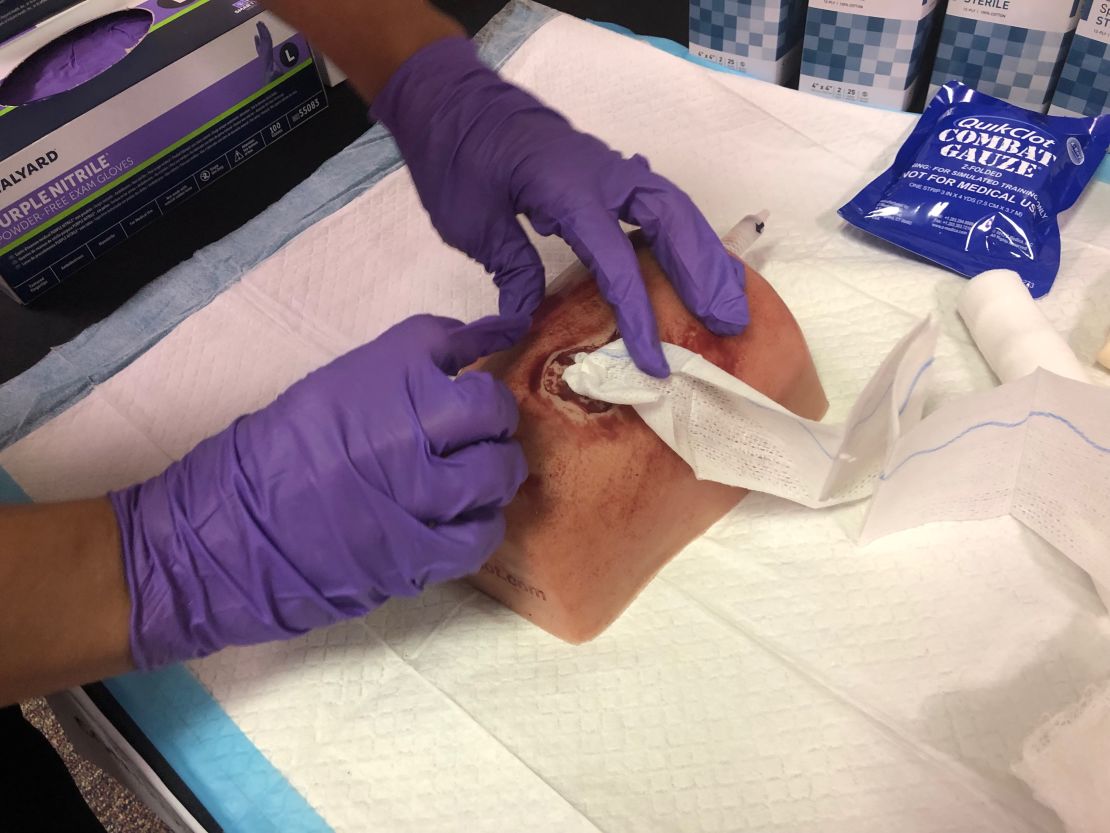 An attendee of the Stop the Bleed class uses a dummy to practice packing a wound with gauze.