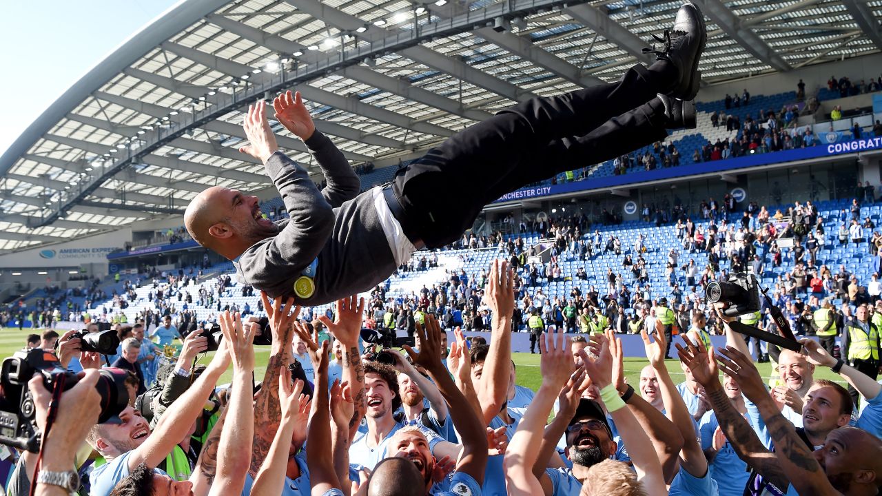 Manchester City players throw manager Josep Guardiola in the air as they celebrate winning the Premier League title following a match against Brighton & Hove Albion at American Express Community Stadium on May 12 in Brighton, England. The final score was 4-1.