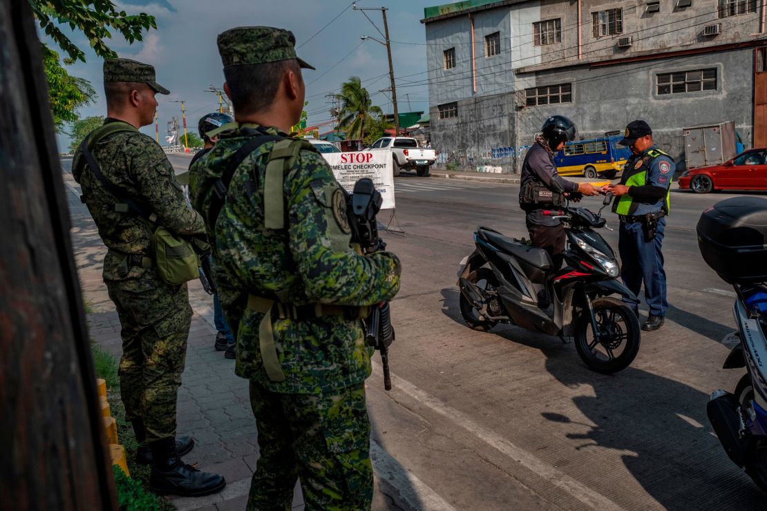 Military and police set up a checkpoint as part of security measures ahead of the midterm elections in Quezon city, Metro Manila.
