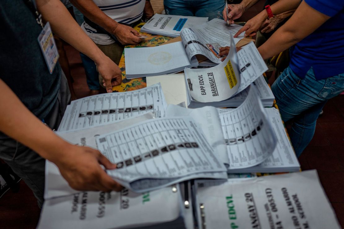 Election workers sort lists of voters at a polling precinct in Manila.