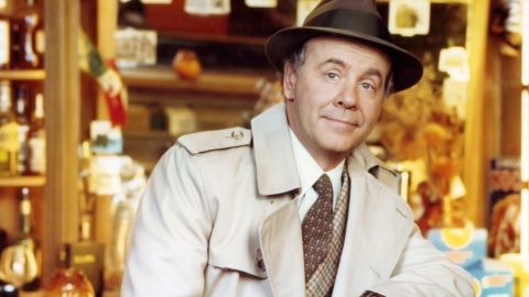 Tim Conway, US actor and comedian, wearing a beige overcoat over a tweed jacket, a white shirt and brown tie, with a brown fedora with a black band, leaning on the back rest of a chair in a studio portrait, circa 1975. (Photo by Silver Screen Collection/Getty Images)