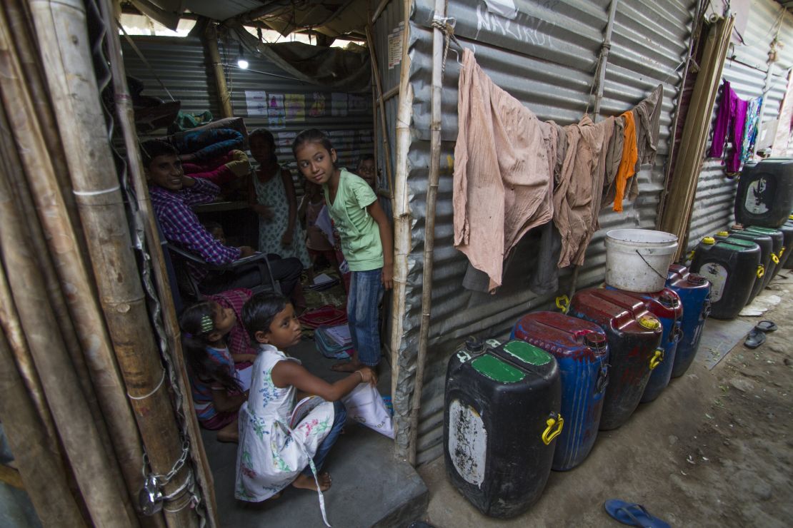 Water containers line every lane and take up every available space in the slum.