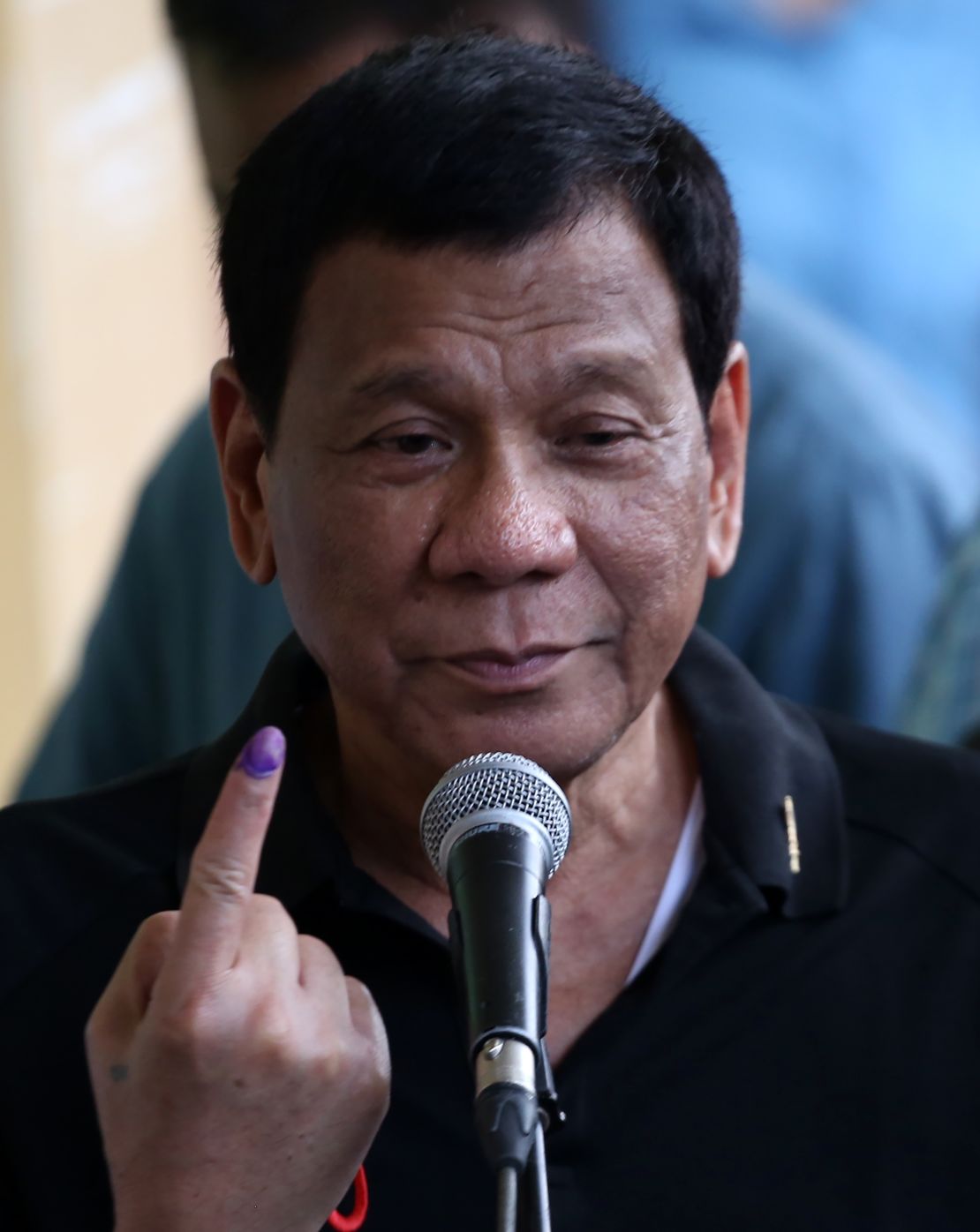 Philippines President Rodrigo Duterte shows the ink on his finger after voting in his hometown of Davao City, where three of his children were on the ballot.